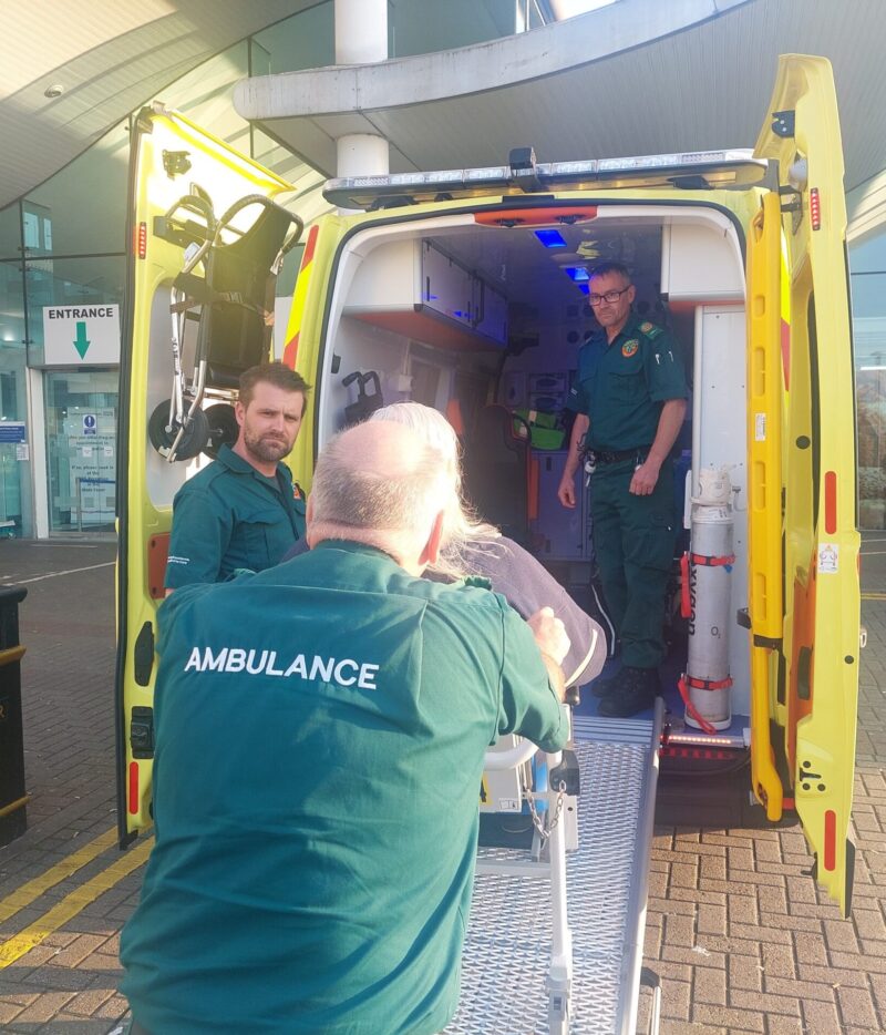 British paramedics assisting a private patient into an ambulance in Jersey for mainland UK transfer