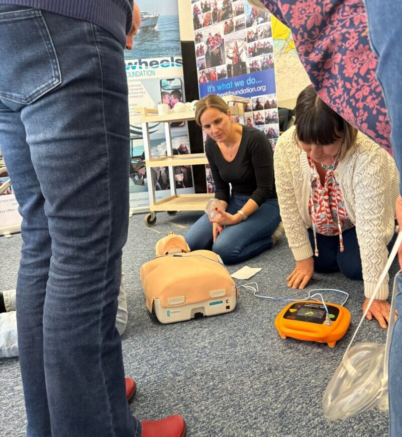 Learners practising CPR and AED use on a manikin during a Qualsafe Emergency First Aid at Work course in Kent.