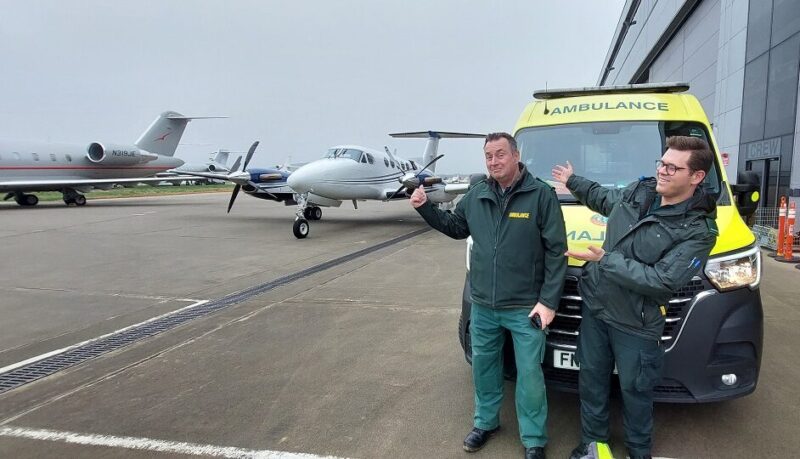 London airport ambulance transfer team preparing for patient transfer between aircraft and hospital on the airport tarmac