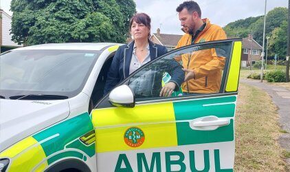 Medical welfare taxi staff assisting a passenger into a welfare appointment car in Kent